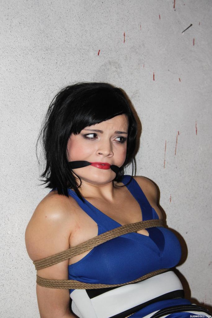 Female with dark hair is gagged and rope bound, leaving her helpless.