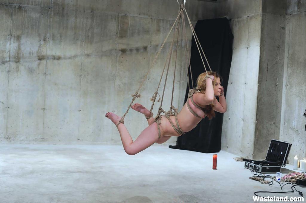 With hot wax and clothespins placed on her scalp, the woman who is suspended in pain cries out in agony.