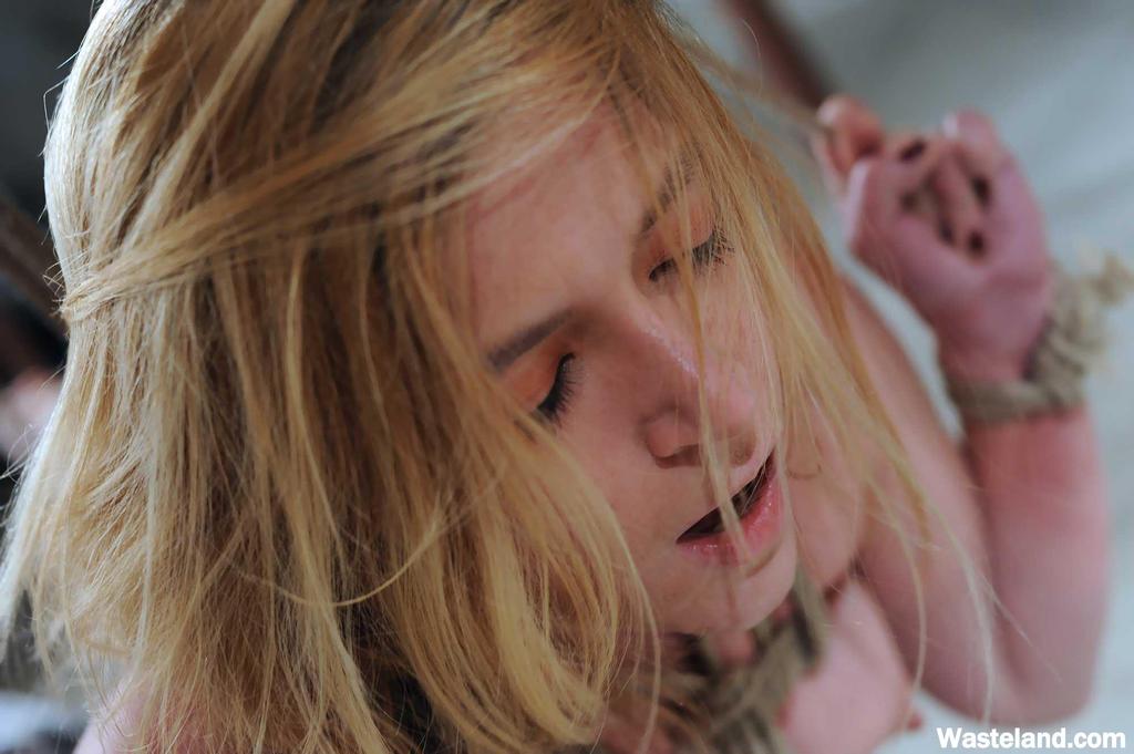 A female body is drenched in agony while being restrained with hot wax and clothespins.
