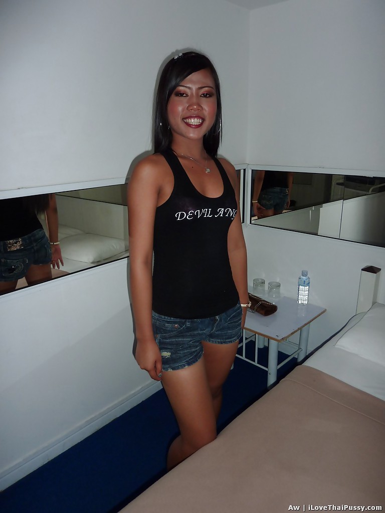 Posing in jeans shorts and a black top, this Asian female appears seductive with her slender legs.