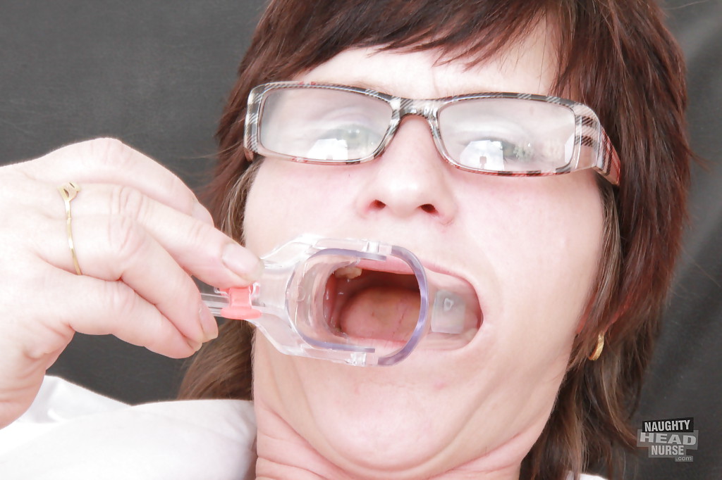 Squished nurse in glasses filling her mouth with toys and gyno equipment.