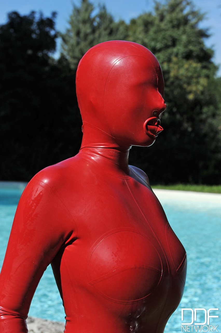 Kinky slut Sandy K poses & masturbates poolside fully covered by a latex suit porn photo #424731893