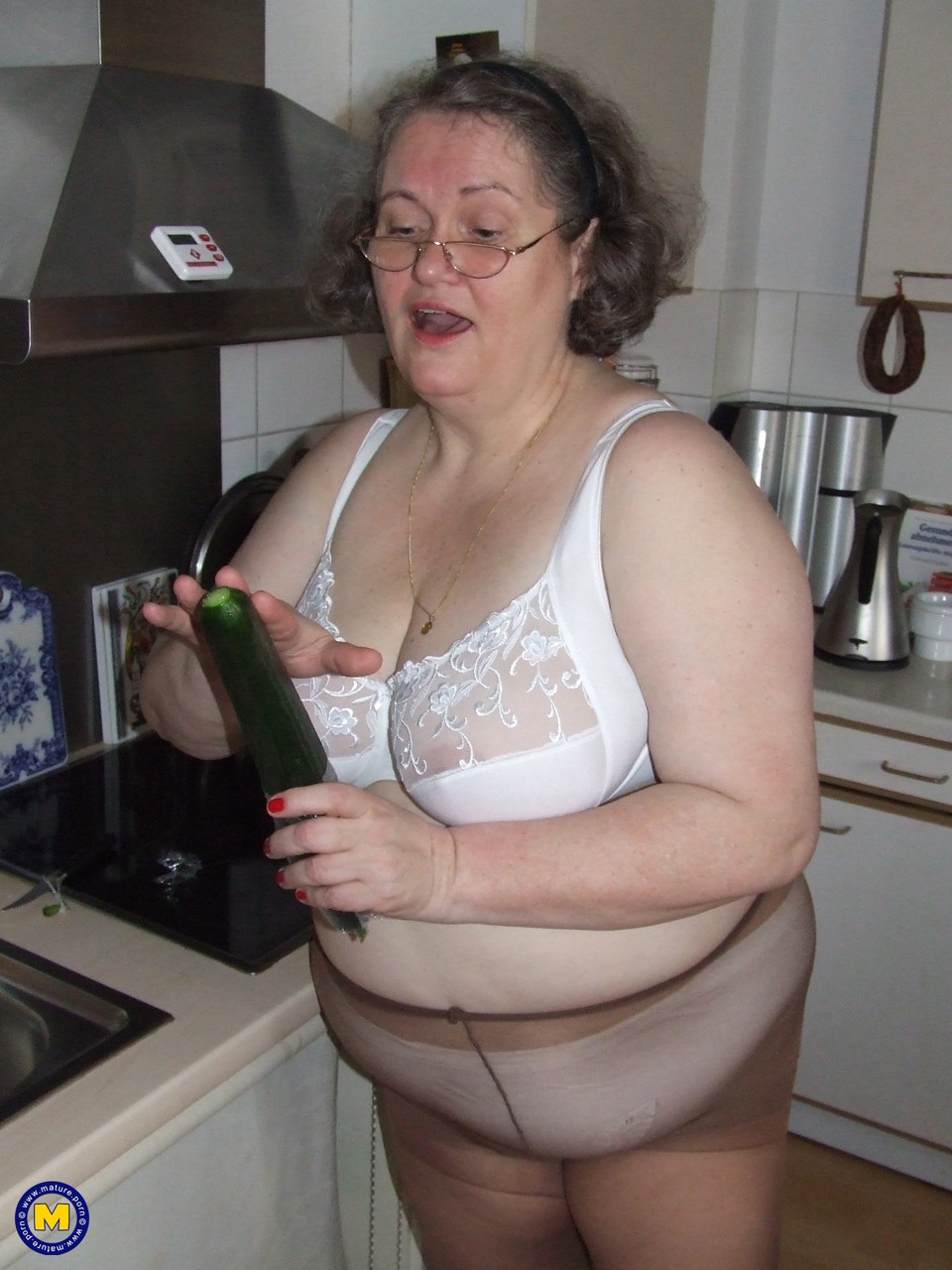Fat mature housewife Birgid masturbates with a cucumber in the kitchen porn photo #423883219