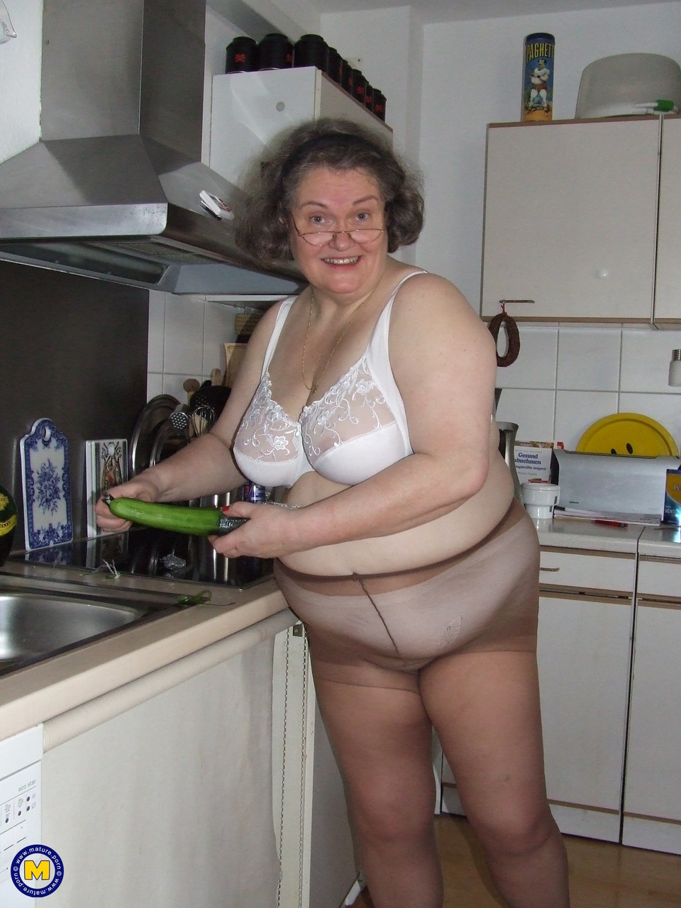 Fat mature housewife Birgid masturbates with a cucumber in the kitchen porn photo #423883220