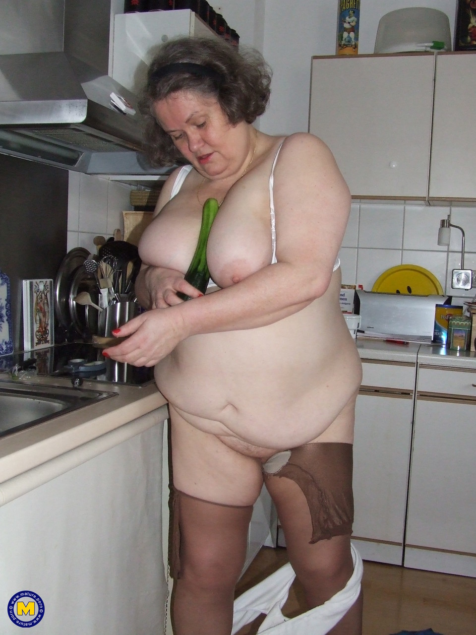 Fat mature housewife Birgid masturbates with a cucumber in the kitchen porn photo #423883225