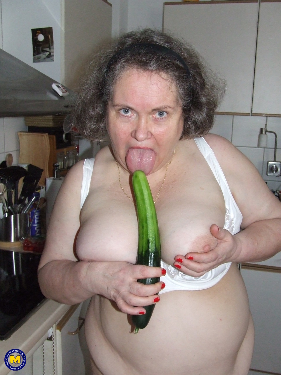 Fat mature housewife Birgid masturbates with a cucumber in the kitchen porn photo #423883226