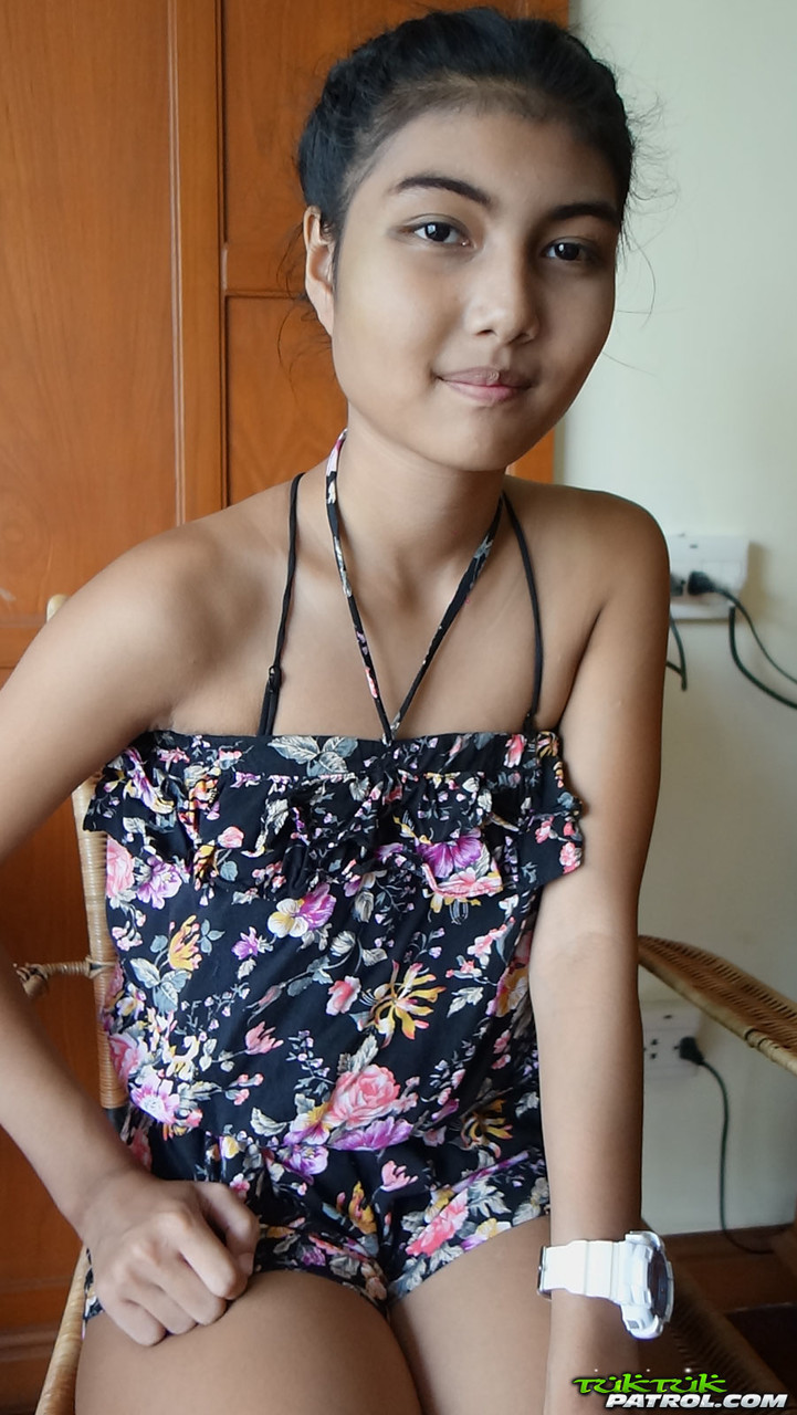 Petite Asian teen Pauw takes off her gown and flaunts her tits and hairy kitty pic