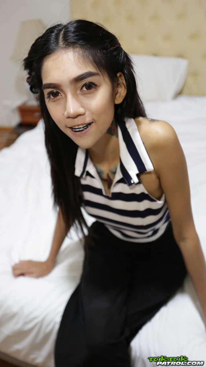 Skinny Thai girl with tattoos and braces makes her nude modelling debut image