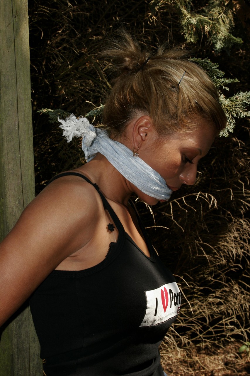 Blonde chick is left bound and gagged to a wooden structure in the woods foto porno #426992843
