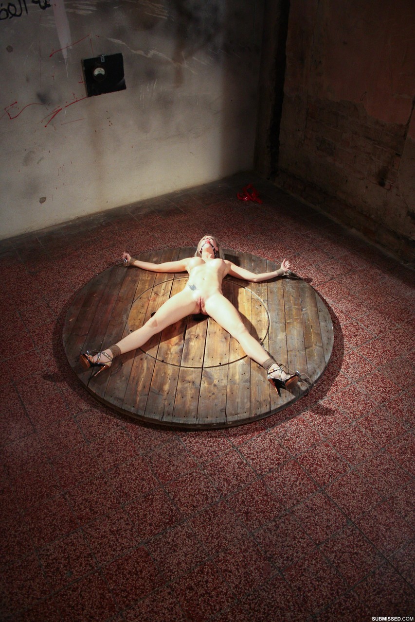 Naked Victoria lays like a starfish being tied to the round wooden scene porn photo #428249714