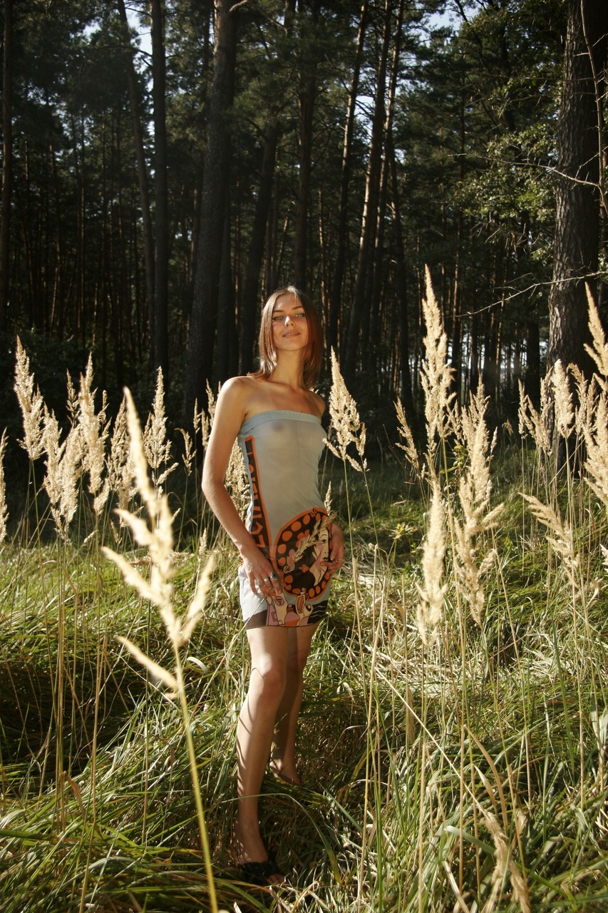 Teenager Nana undresses herself while posing in nature.