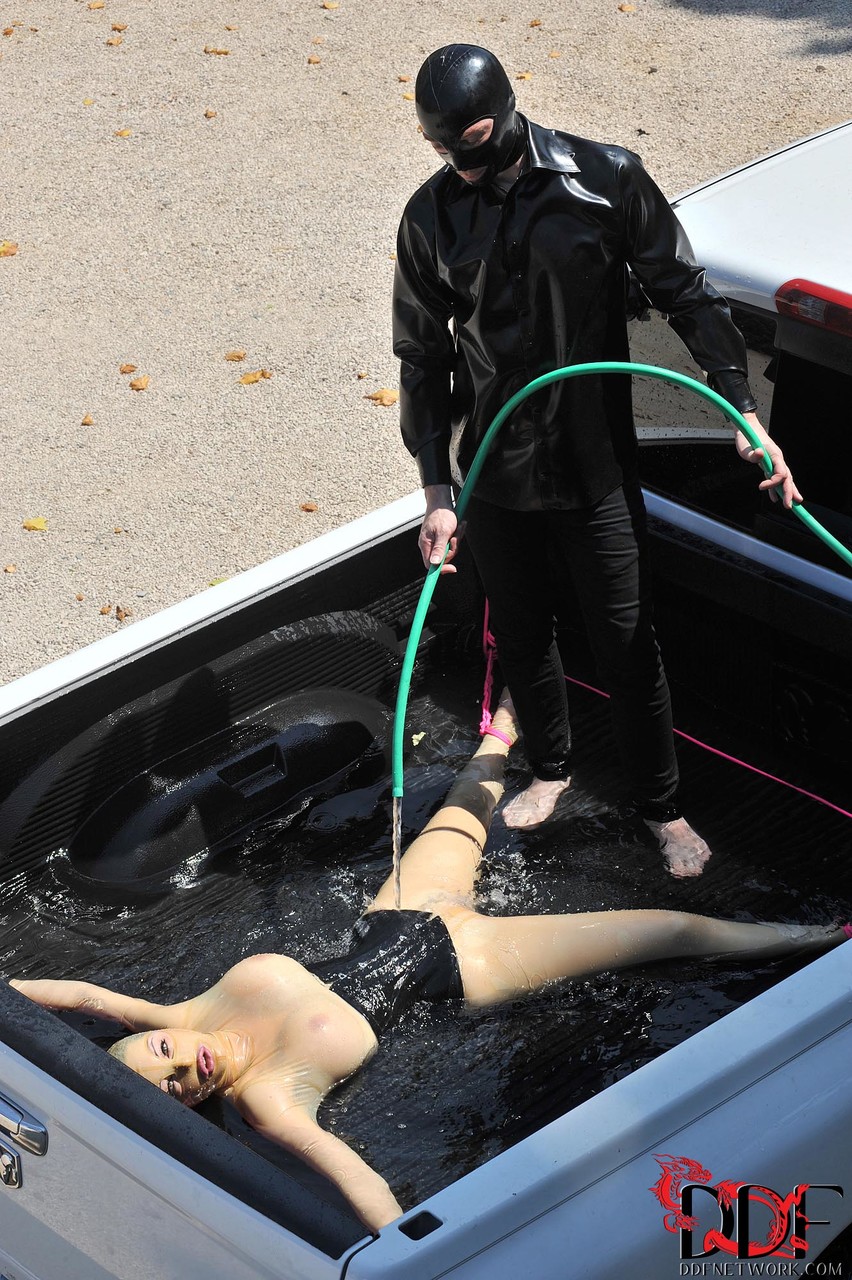 British girl in latex Latex Lucy gets tied on a truck & water jetted in BDSM porn photo #422512027