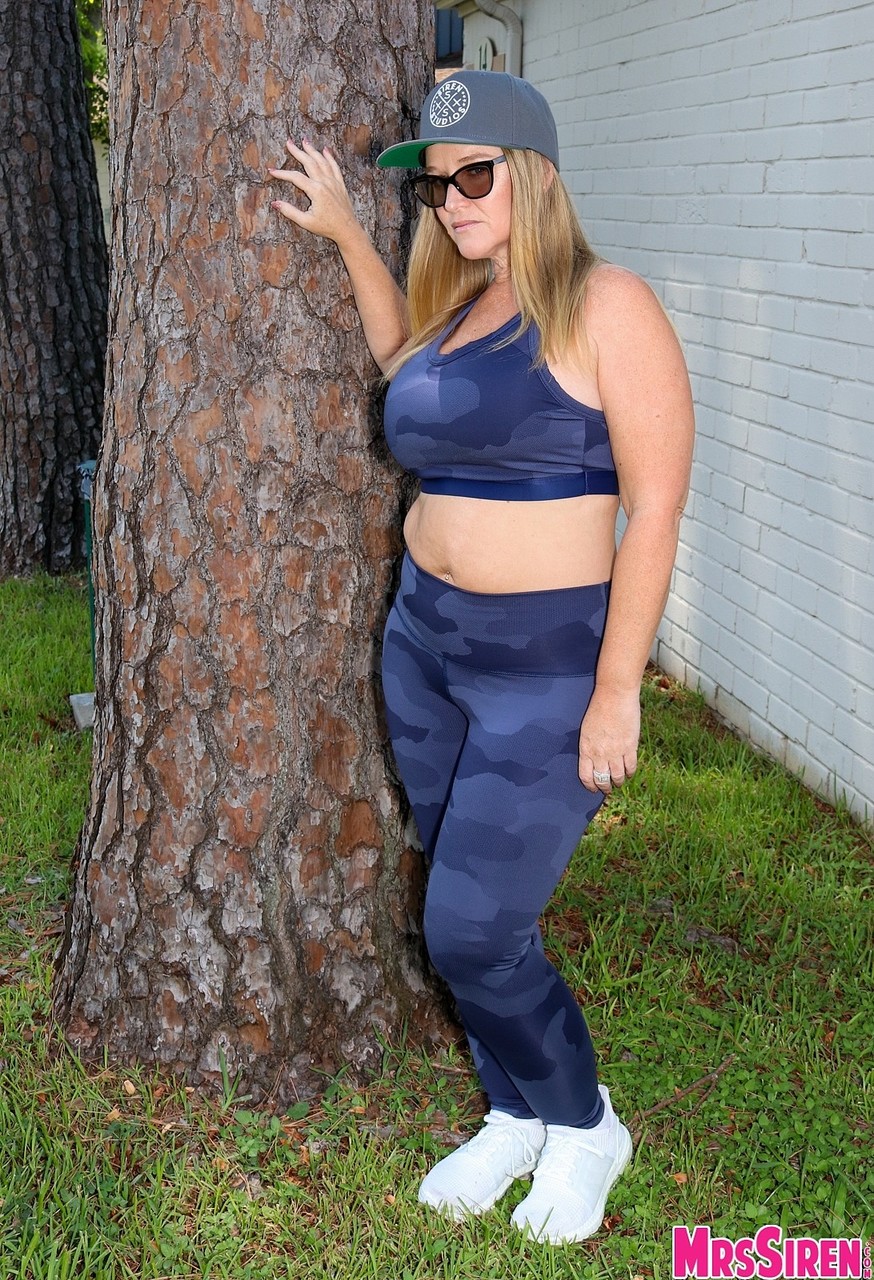 Short cougar Dee Siren posing in her sexy leggings and top in the garden foto porno #428403023