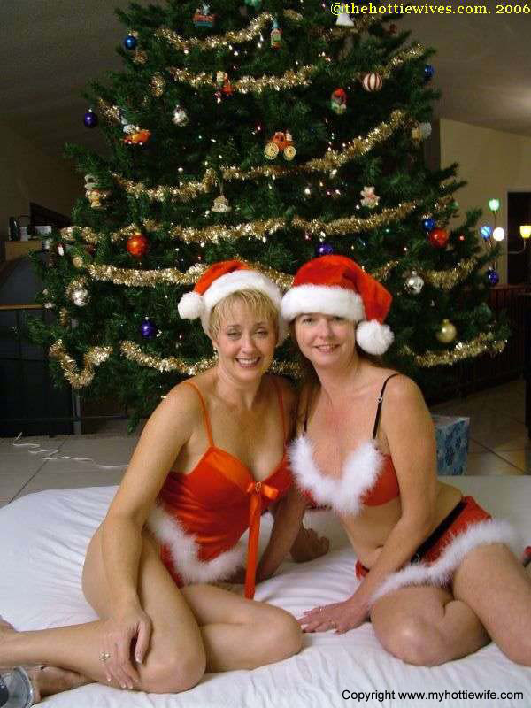 In Xmas attire, amateur swingers playfully in front of a Christmas tree to cheer on each other.