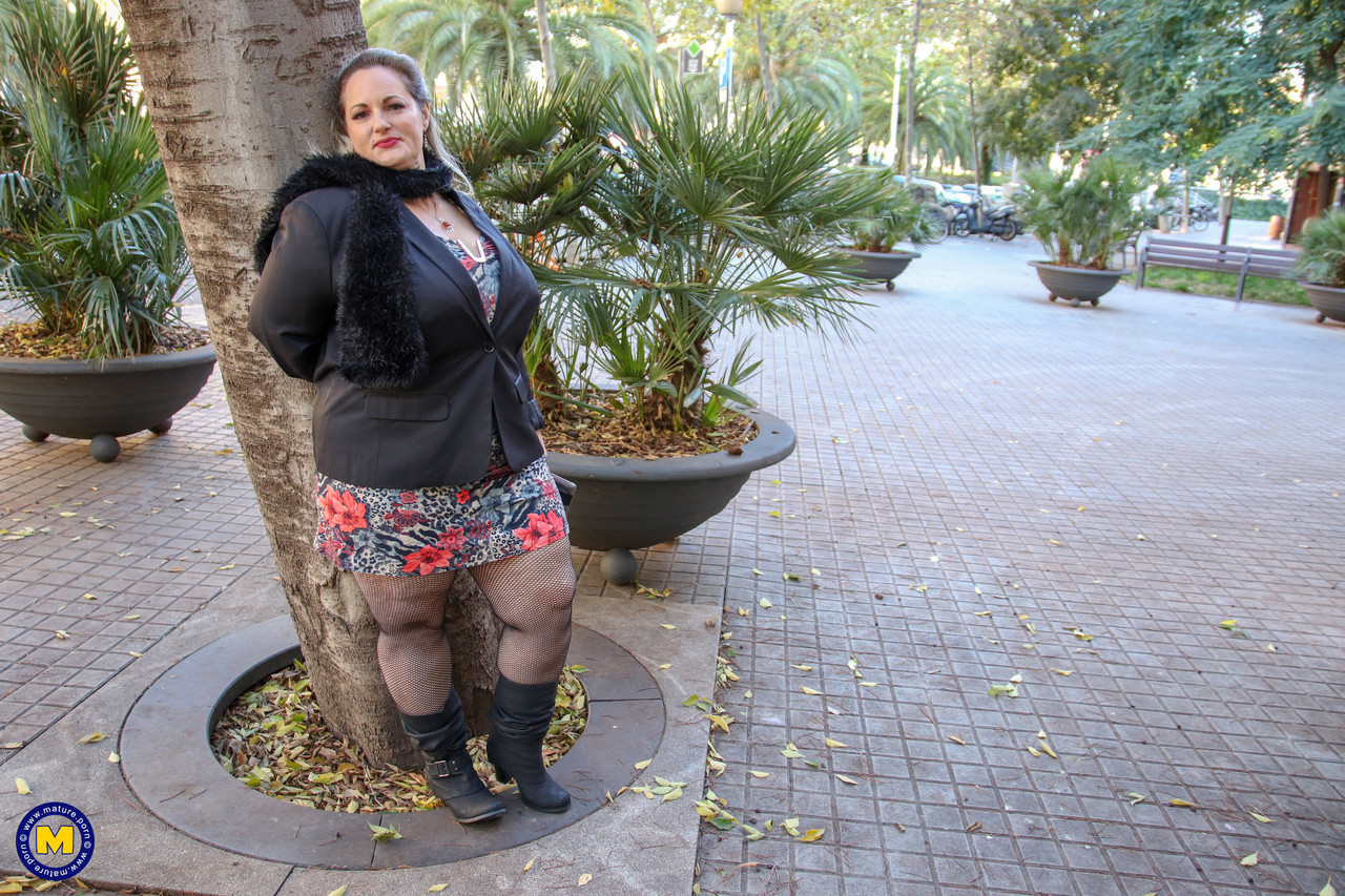 Hot mature BBW Sophia Lola showing her clothed big breasts outdoors.