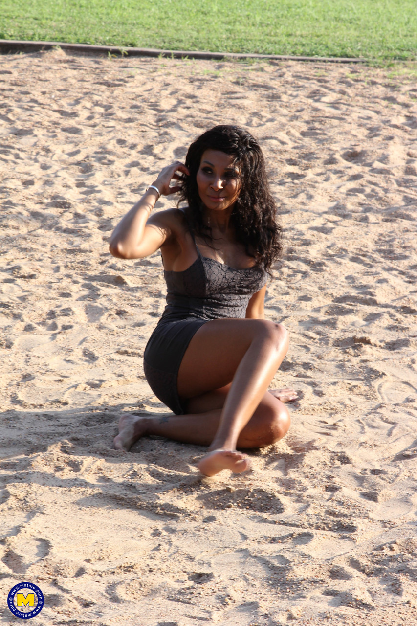 Ebony doll in tight dress Lilly Dee posing pantyless in the sand foto porno #427199415