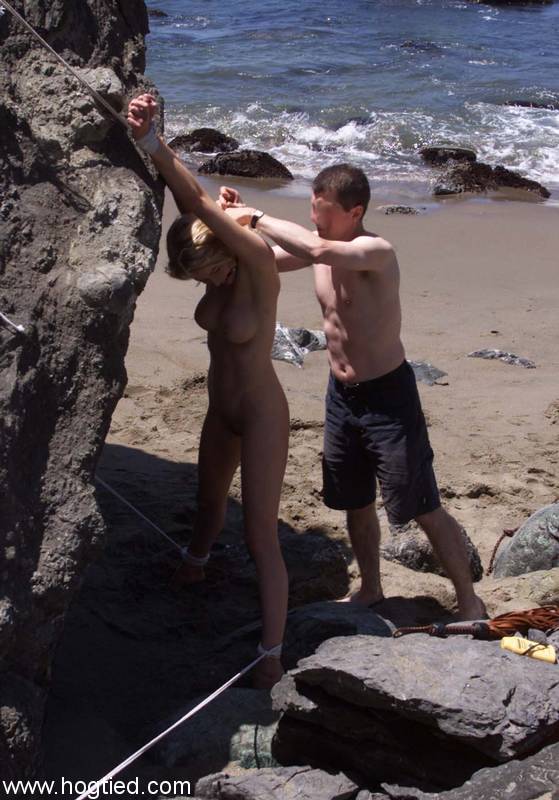 Nude mature slave Sadie Belle gets tied to a huge rock on the beach porn photo #425593708
