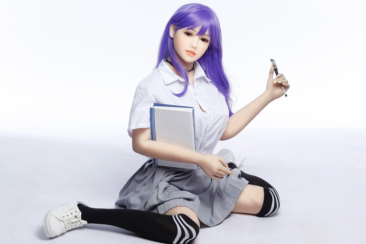 Purple haired sex doll Hikari poses in a schoolgirl skirt. 