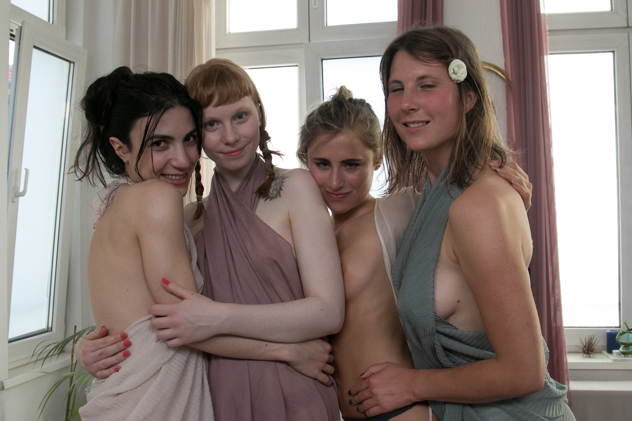 Cute lesbian women frolic and give each other kisses while being nude.