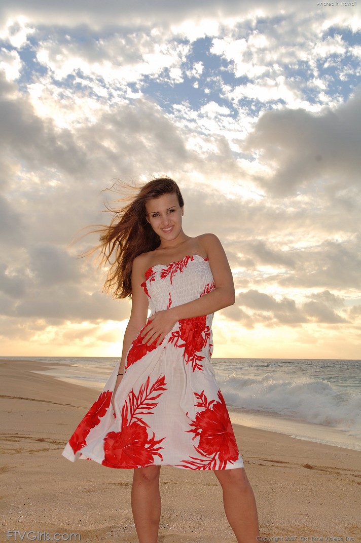 On the beach, a playful Andrea poses in her summer attire, donning a loose dress and posing in the nude.