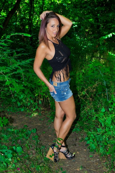 In a wooded scene, Nikki Sims from the MILF sheds her shorts to pose as a non-nude member in black Thong style.