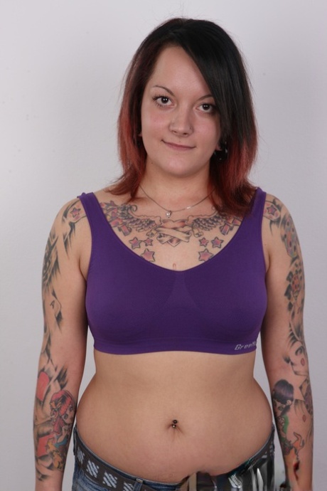 After tattooing, Vendula, an amateur tattoo artist, removes her clothing from her chubby body.