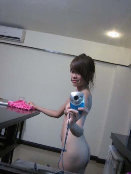 This daring young Asian girl takes pictures of herself in a mirror while getting naked.