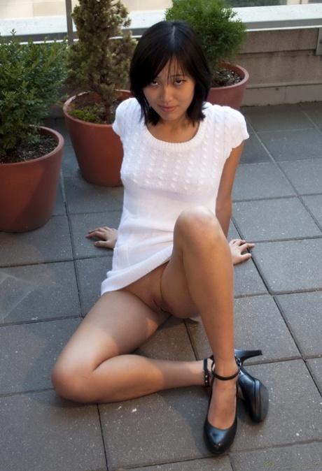 With her Asian twats, Annie is naked and sitting on a chair.