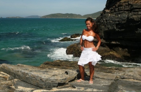 Asian teen makes her nude modelling debut as the surf pounds the coast below