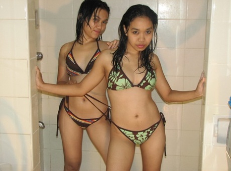 Young Asian amateurs are naked and enjoy a lesbian kiss in the shower.