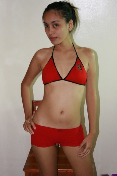 For the nude posing, an Asian girl removes her small red shorts and bikini.