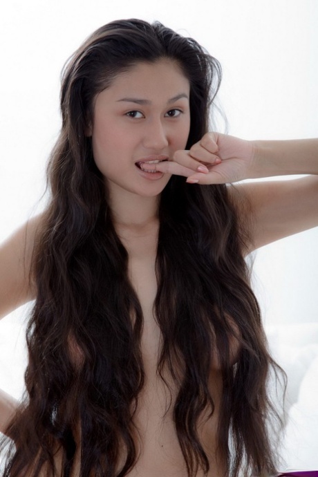 An Asian female with long hair that reaches her ass exposes the visible spots of her lack of hair.