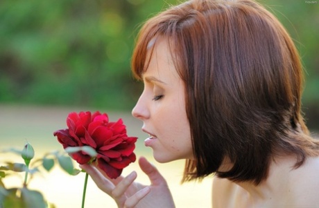 Naked Redhead Pauses To Smell A Flower While Out On The Lawn