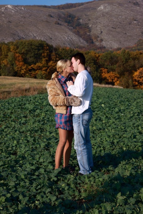 Sex: A blonde girl and her boyfriend have sex outside in a grassy field away from eye contact.