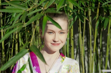 Sexy little geisha Emily Bloom spreading naked to show bald twat in the bamboo