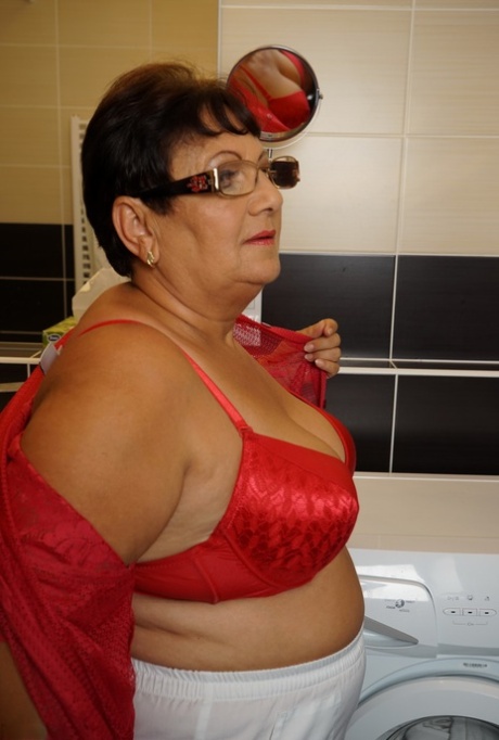 The old woman who is overweight is being bathed by her toy boy in the bathtub.