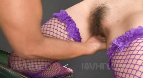 A peach-tinged vibrator is present on the Misaki Aiba Asian of mauve fishnets.