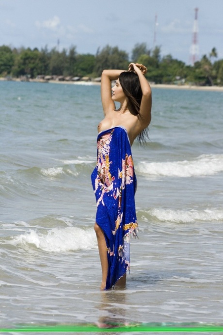 Азиатская любительница бродит по пляжу в одних плавках бикини