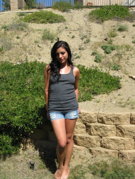 A fence in the backyard is the location where Kelly Xoxo, a Latina girl, exposes herself.