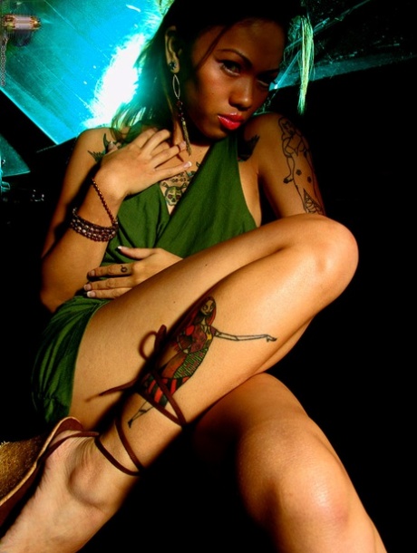 Naughty: This naughty, tattooed asian girl strips herself in a car while driving home.