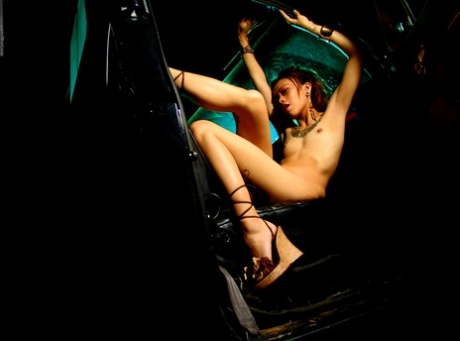 While in a car, an unfeeling Asian girl with tattoos strips her own hair.