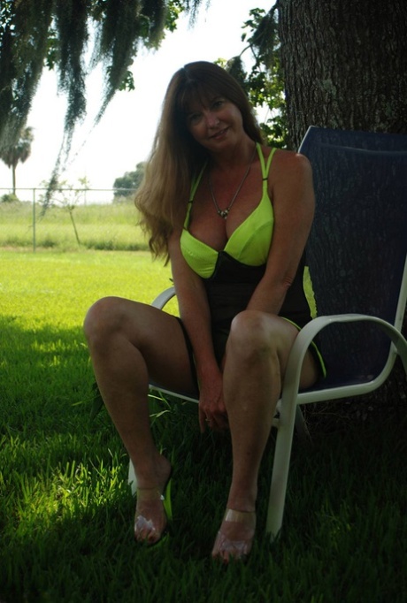 Under a shade tree, Dee Delmar pretends to be a passerby in see-through lingerie as a young amateur.