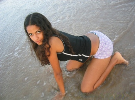 At the beach, Polliana, a small Brazilian girl, is seen wearing a barefooted top and lifting her swimsuit.