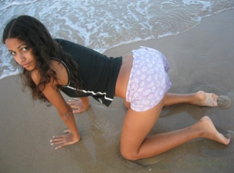 Polliana, a small Brazilian girl on the beach, is seen wearing a tank top while baring herself.