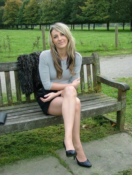 Leg model poses on a country bench in black skirt and pumps