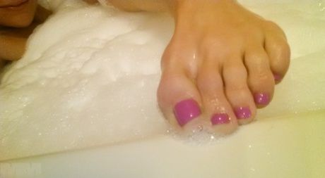 While bathing, amateur girl Meet Madden displays her painted toenails.