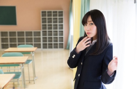 Милая японская школьница стягивает трусики, показывая голую попку в библиотеке