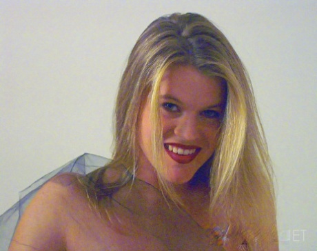 During modelling in lingerie, Taryn, an amateur model, displays her tongue with big teeth and sticks it out.