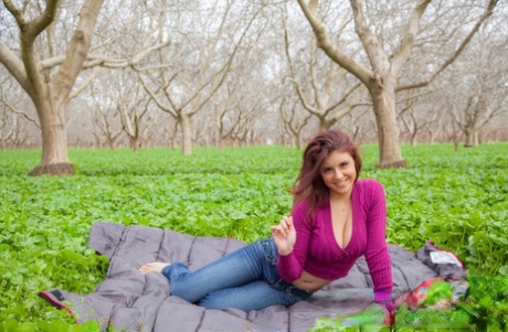 In the park Aubrey Chase removes her purple sweater and displays it with big boobs on top.