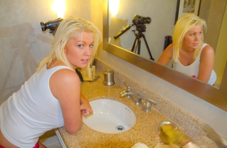 In the midst of her amateur career, blonde Brooke Alexander releases her large breasts from a wet shirt.